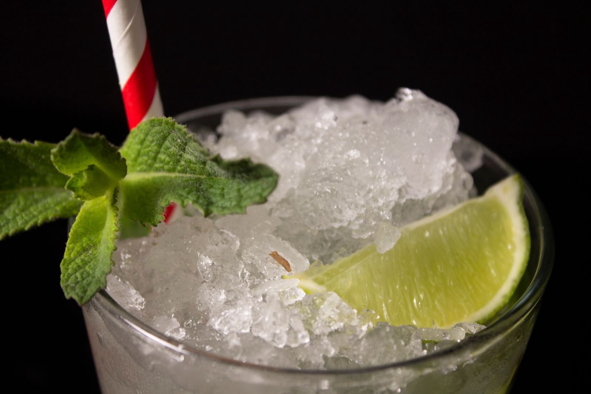 A mojito packed with crushed ice, fresh mint and a wedge of lime.